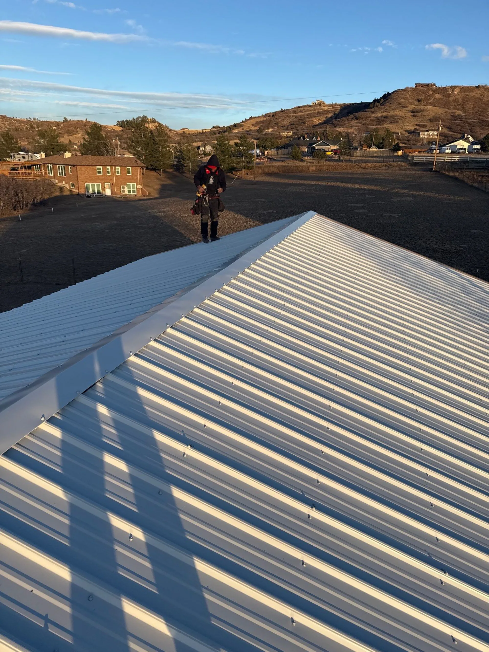 Completed metal panel roof with ridge cap on a Castle Rock property.