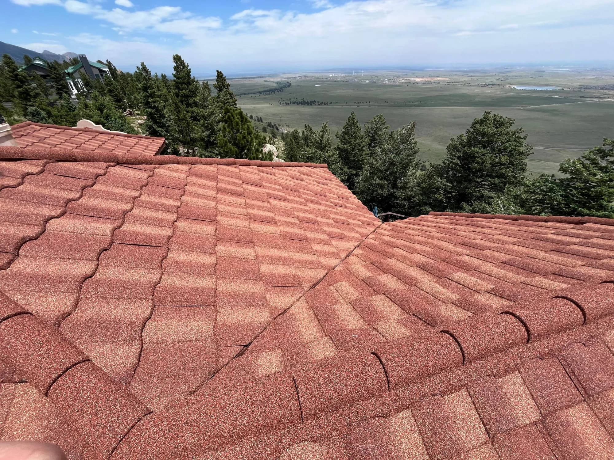 Ridge and hip detail on a completed stone-coated steel roof in the Golden foothills.