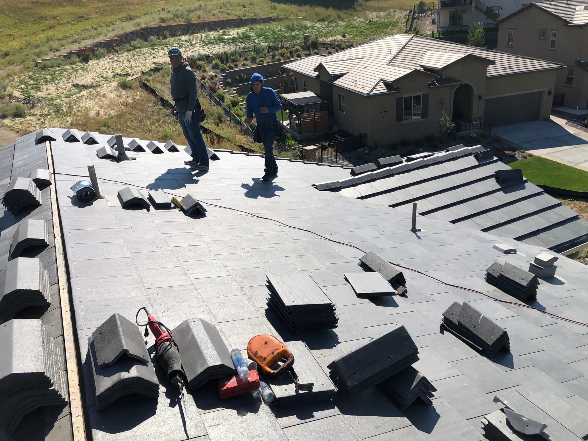 Red Hawk crew setting concrete tile and ridge pieces on a Lakewood roof.