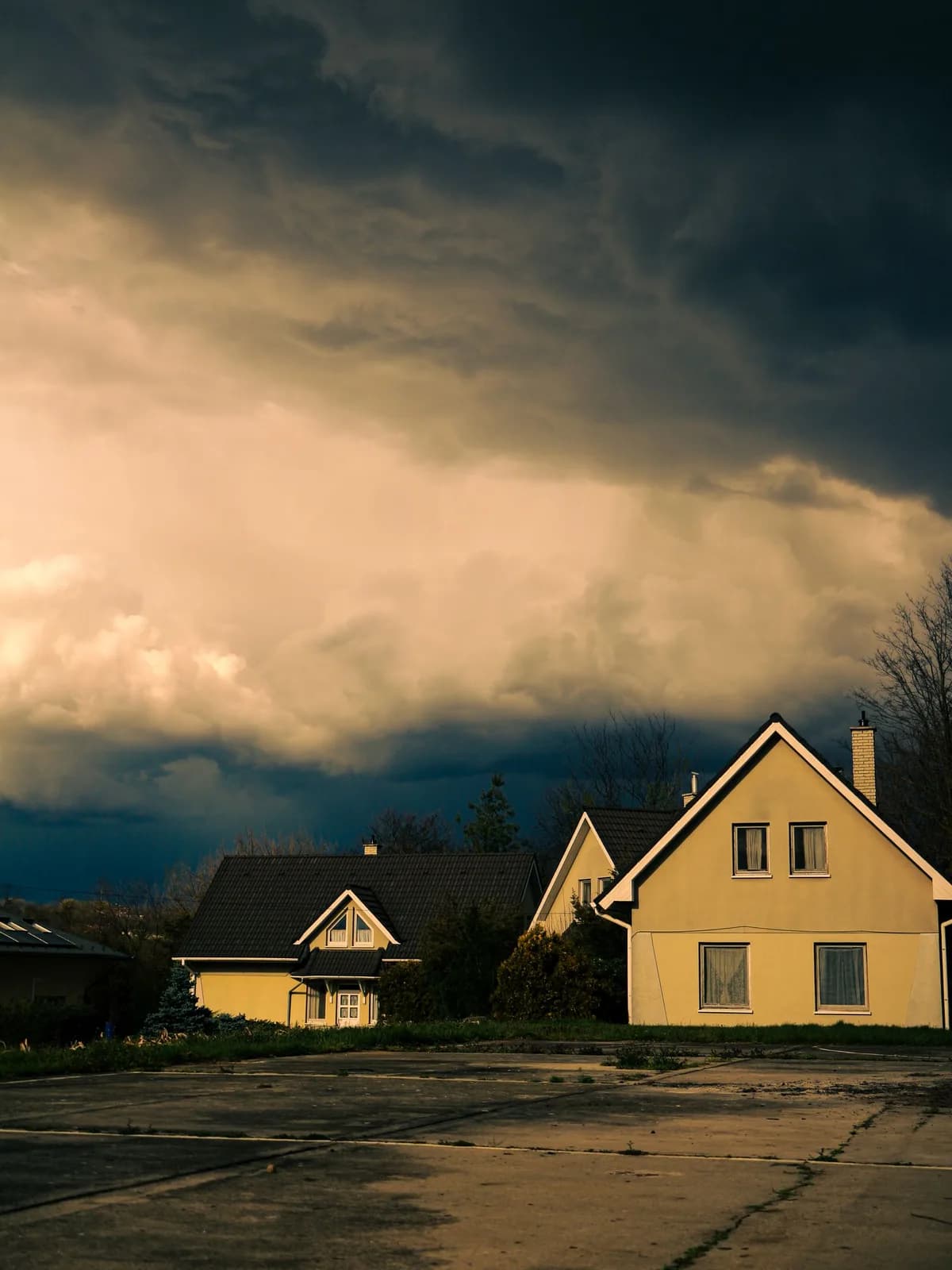 Dark storm clouds gathering over residential homes ahead of severe weather.